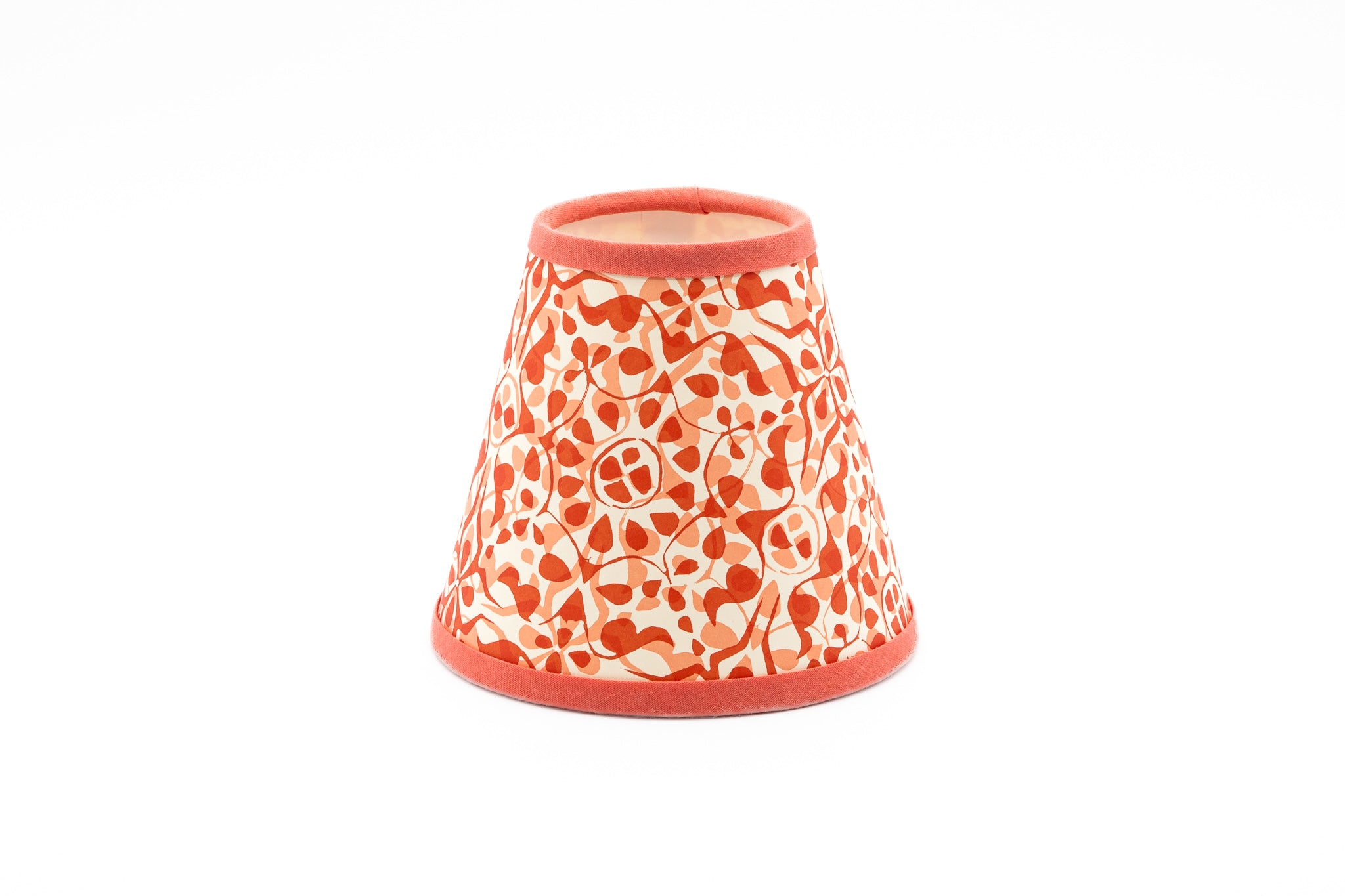 A small decorative lampshade with a coral orange and white floral pattern, shown on a plain white background.