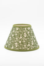 A conical paper lampshade with an olive green background and a cream-colored floral and vine pattern, finished with solid olive green trim at the top and bottom.