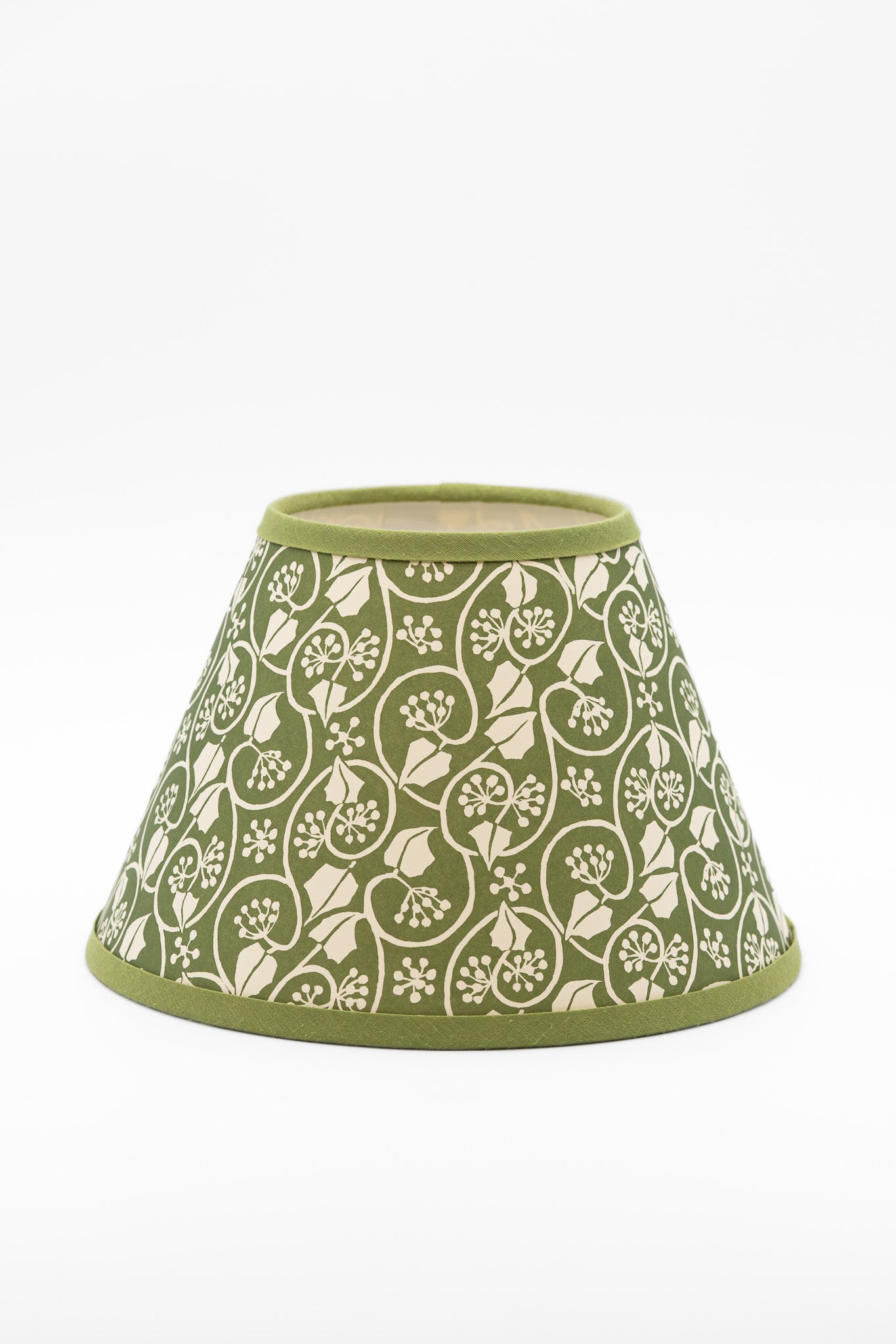 A conical paper lampshade with an olive green background and a cream-colored floral and vine pattern, finished with solid olive green trim at the top and bottom.