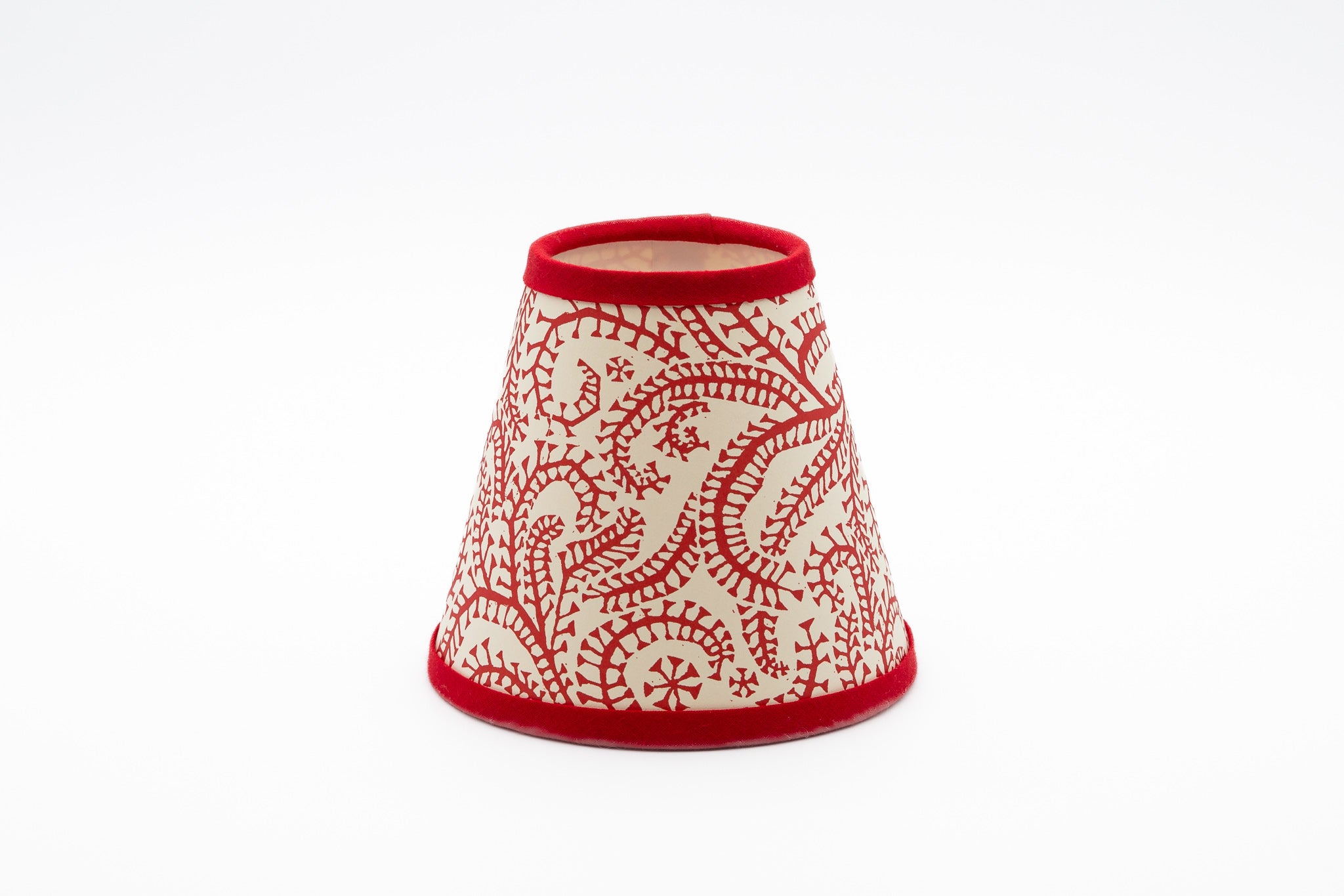 A small paper lampshade with a red and cream paisley pattern and solid red trim, shown on a plain white background.