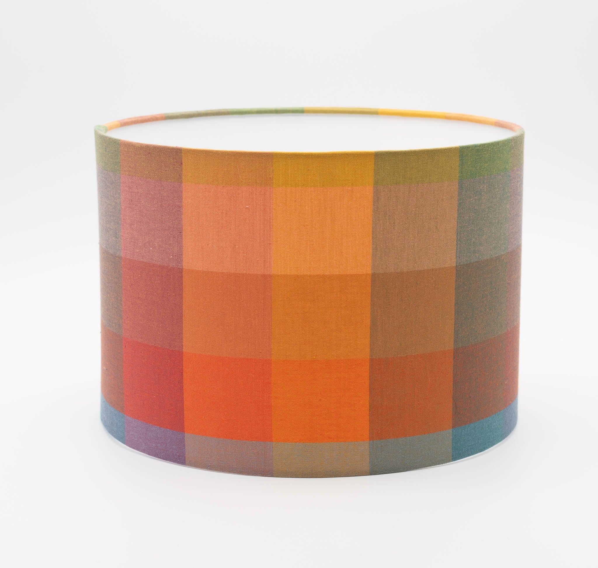 Autumn Squares lampshade — warm red and gold geometric check on a cotton drum shade.