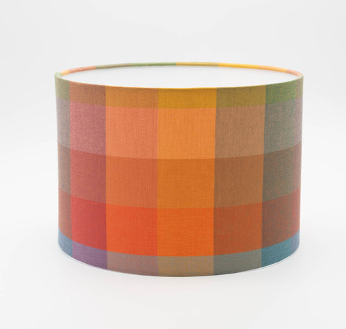 Autumn Squares lampshade — warm red and gold geometric check on a cotton drum shade.