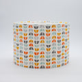 Half Moon Spice lampshade — warm orange and red half-moon pattern on a cotton drum shade.