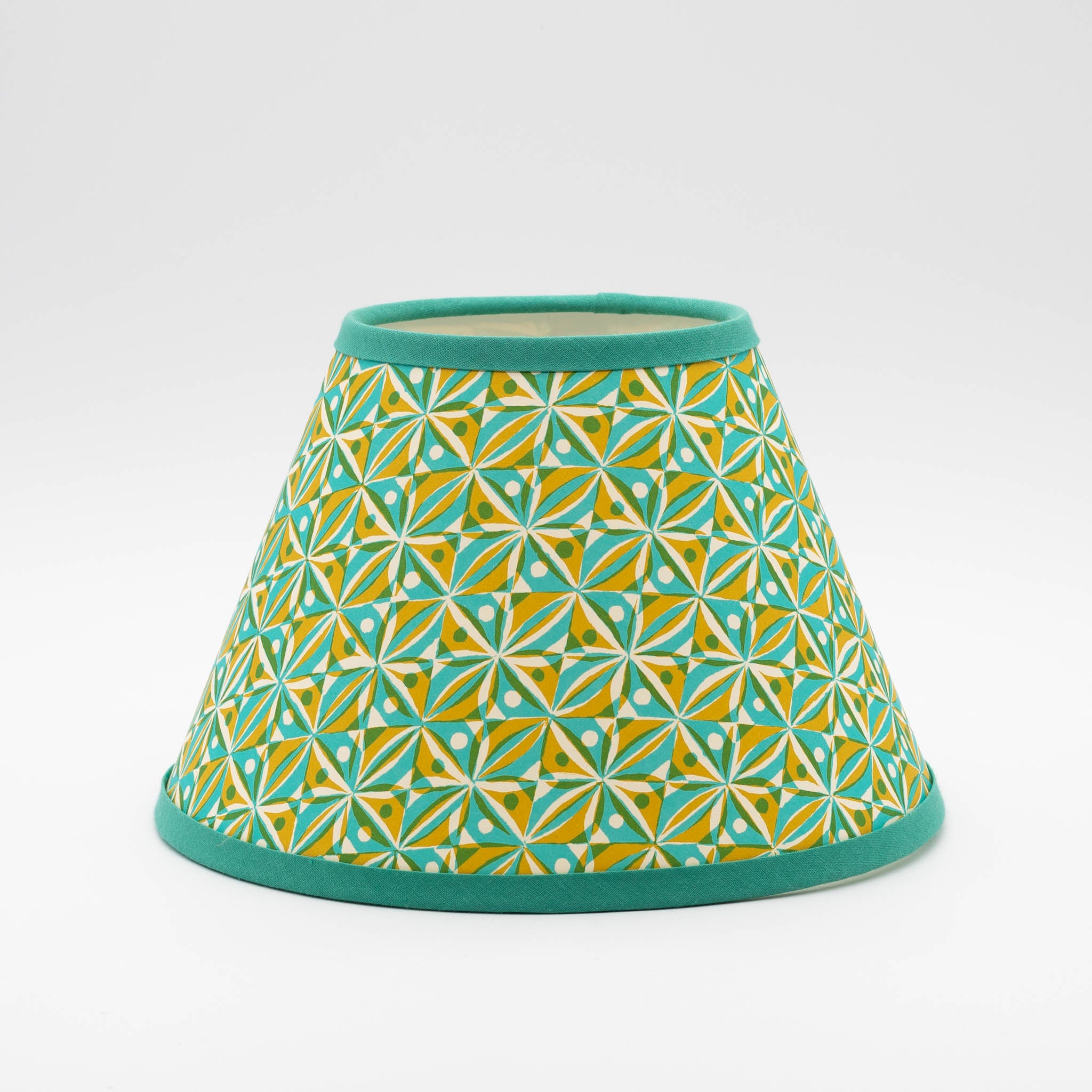Kaleidoscope Turquoise lampshade — kaleidoscopic geometric pattern in turquoise and gold on a conical paper shade.