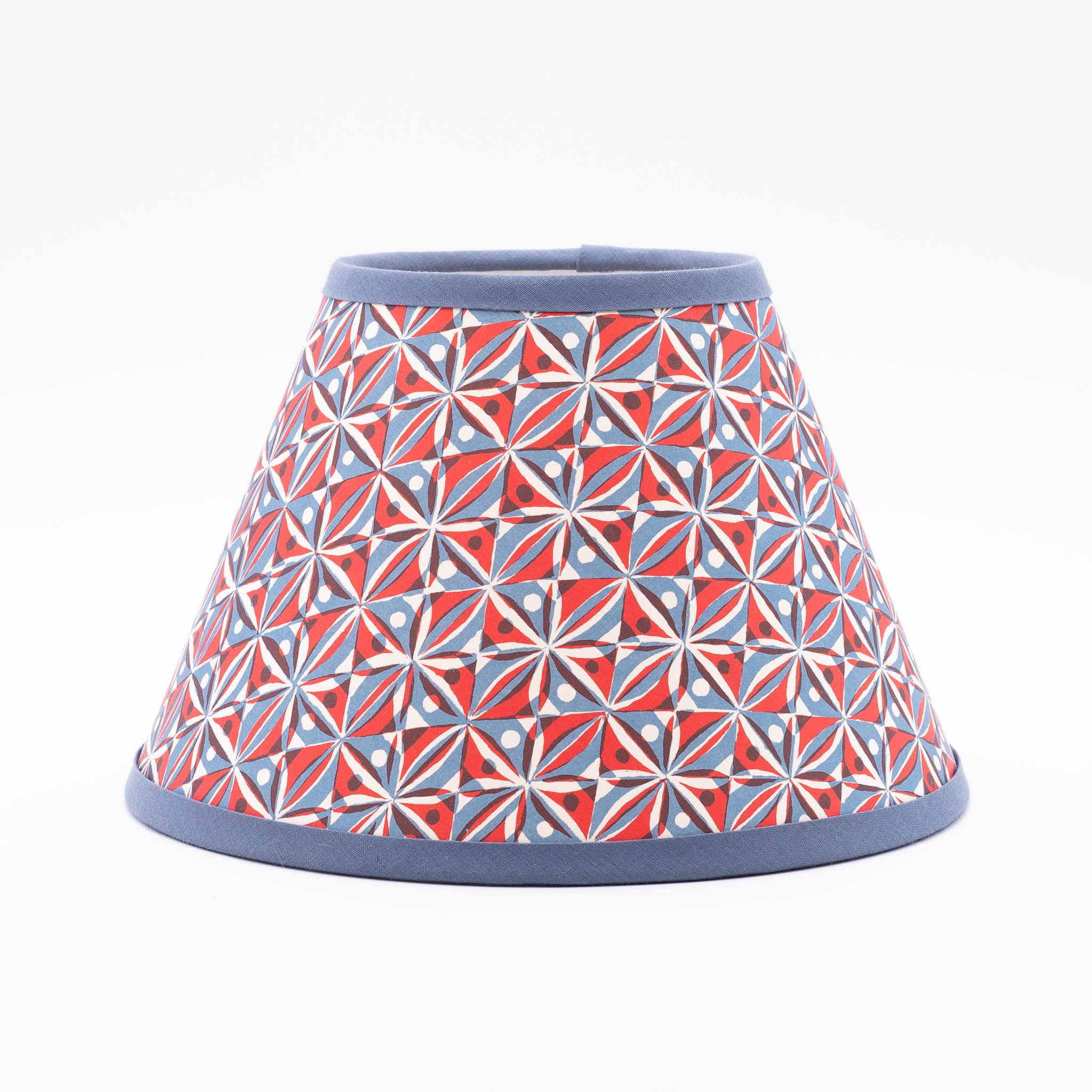 Kaleidoscope Red lampshade — kaleidoscopic geometric star pattern in red on a conical paper shade.