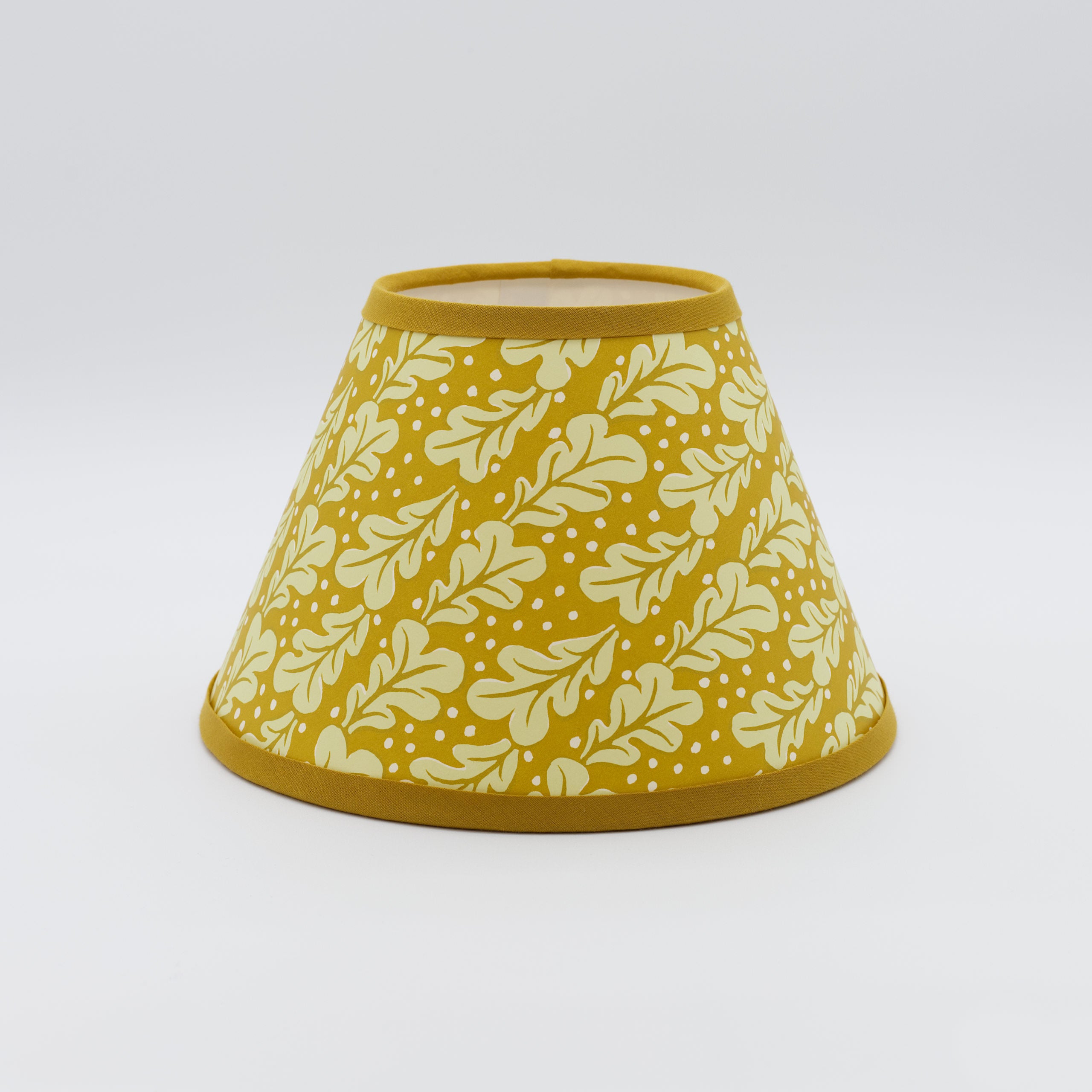 Quercus lampshade in sap green — oak-leaf pattern on a handmade conical paper shade.