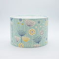 Seedheads lampshade in soft teal — botanical seedhead pattern on a cotton drum shade.
