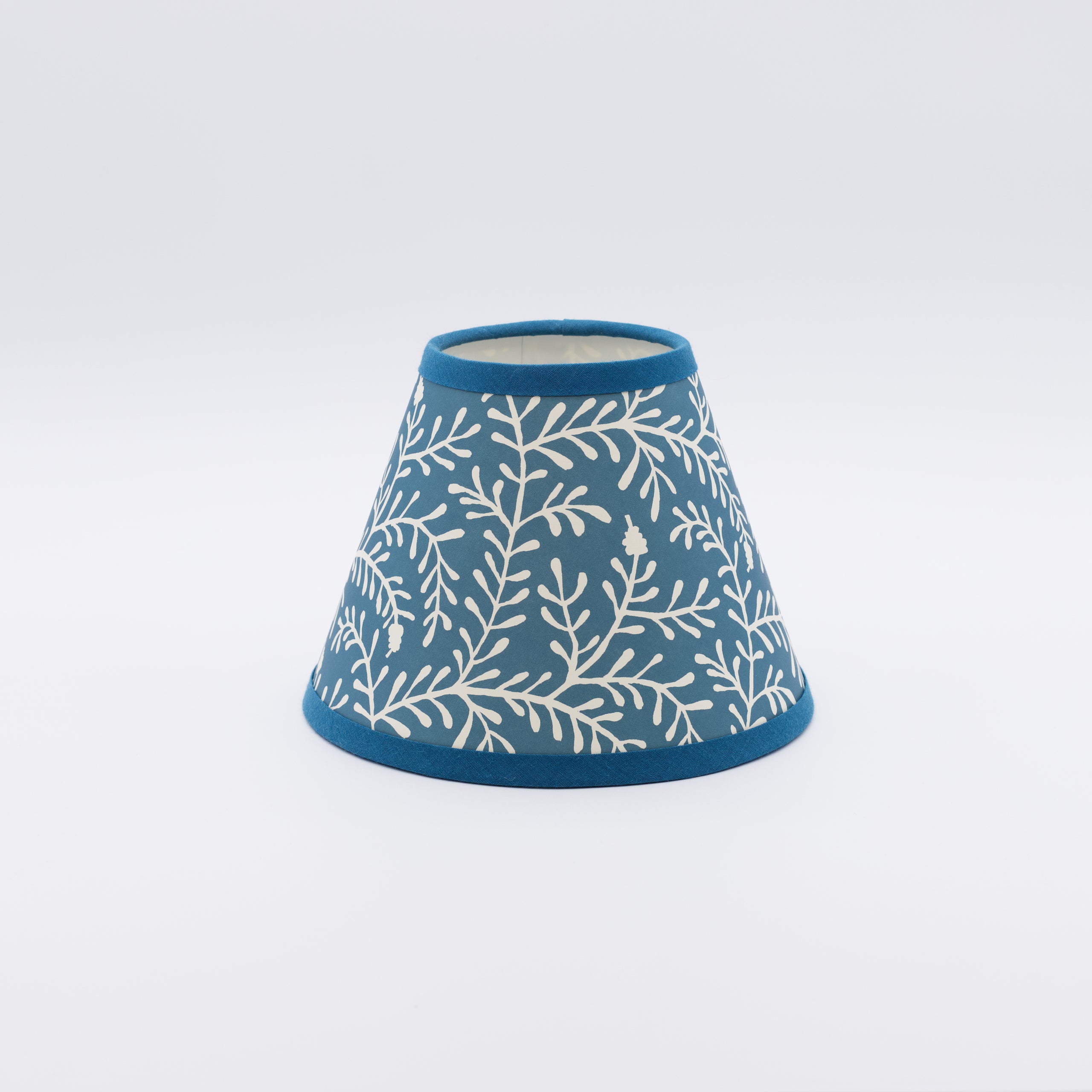 Sprig lampshade in marine blue — small leafy sprig pattern on a handmade conical paper shade.