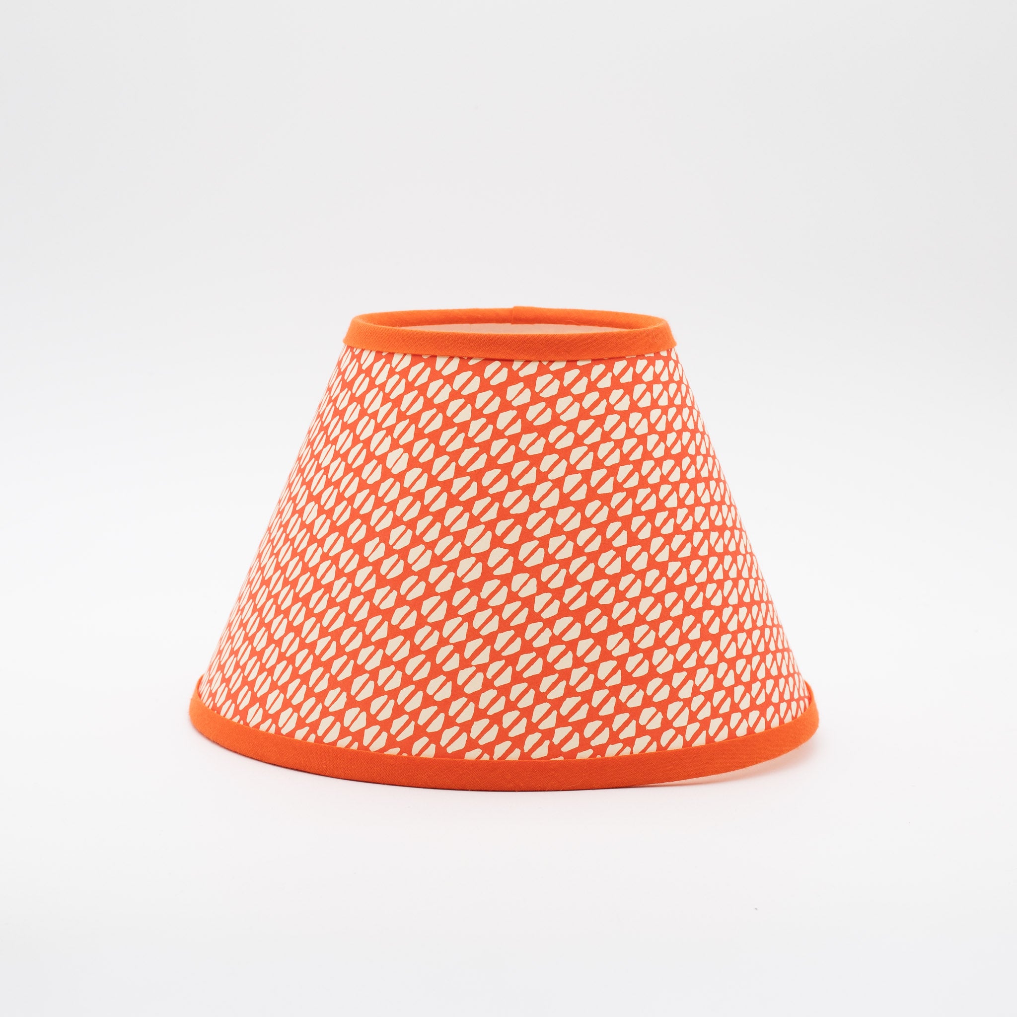 Yo-yo Tomato lampshade — tomato-red wavy ogee pattern on a handmade conical paper shade.